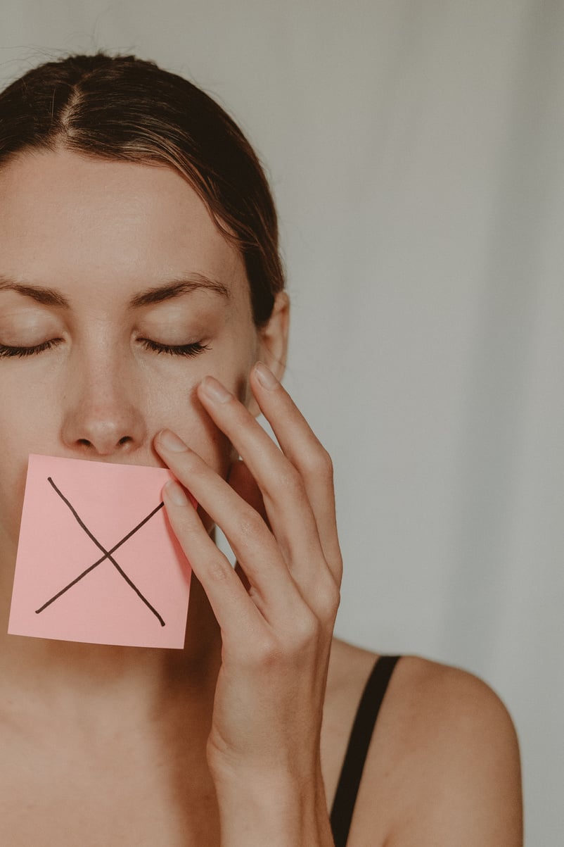 Woman with cross symbol on mouth unable to speak